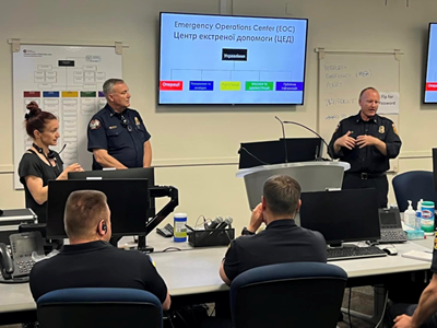 Photo of Cal Fire personnel with a translator speaking to Ukraine visitors in the county Emergency Operations Center with a presentation