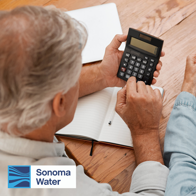 Imagen de un hombre mirando una calculadora y papeles con el logotipo de Sonoma Water.