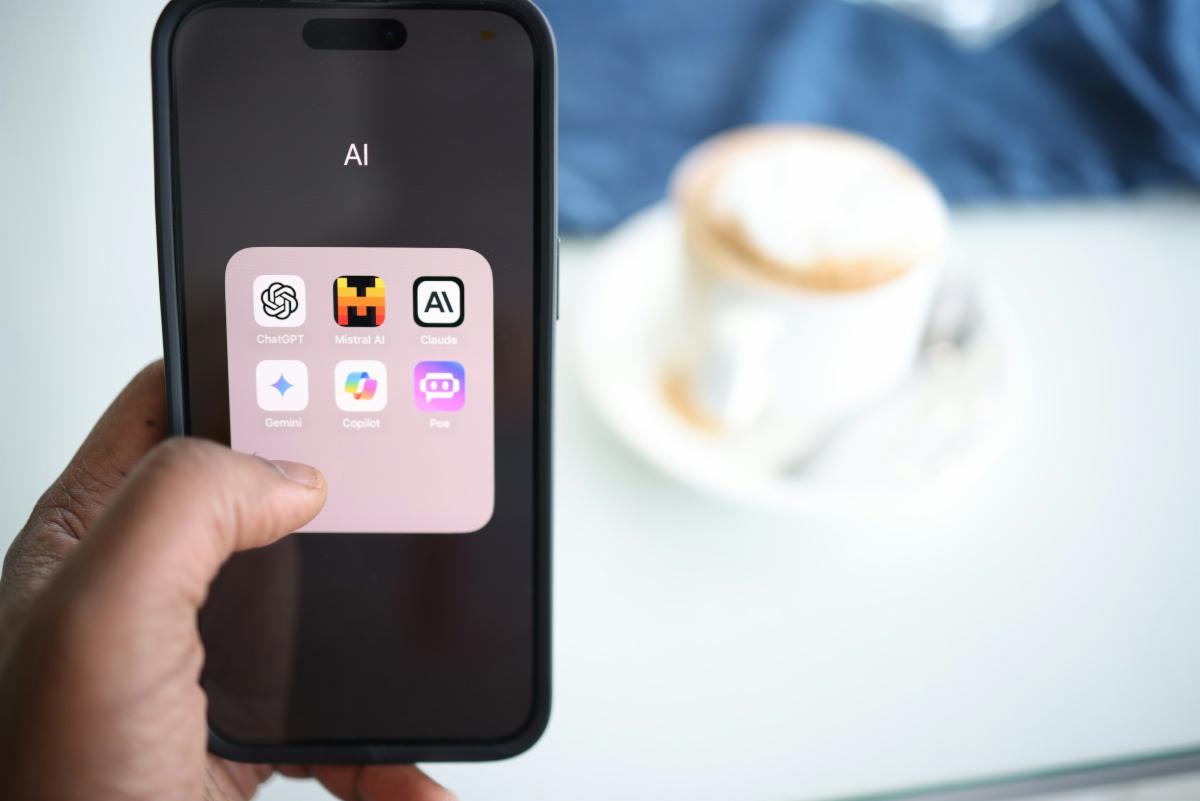 Photo of a person's hand holding a mobile phone with AI apps on it.  Photo by Solen Feyissa on unsplash.