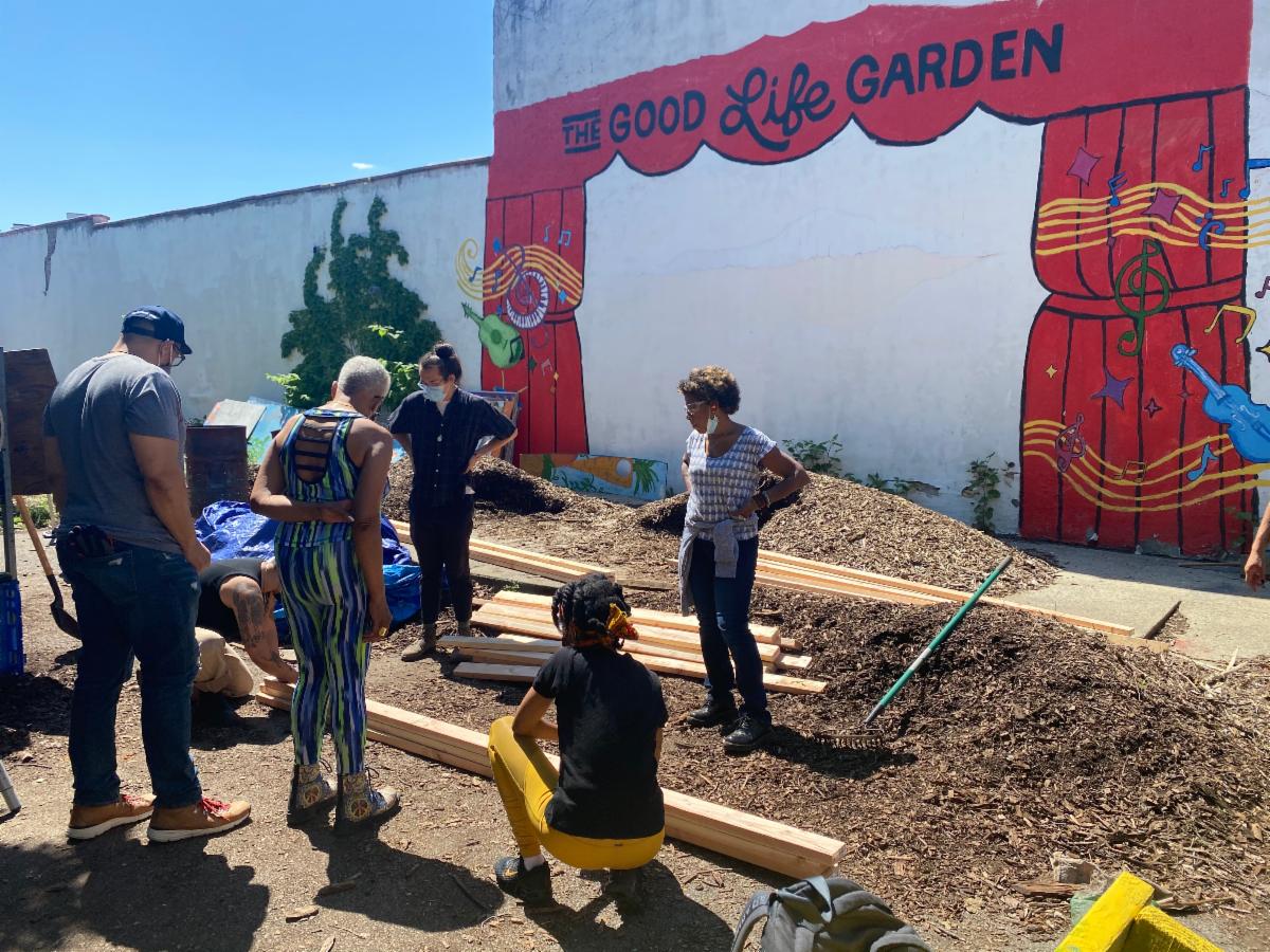 Measuring and preparing to cut wood at the Good Life Garden.