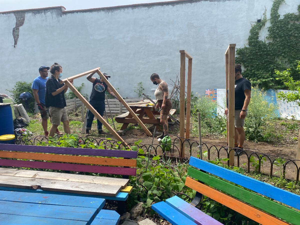 The trellis coming to life as students and co-facilitators work together to get the posts into the ground.