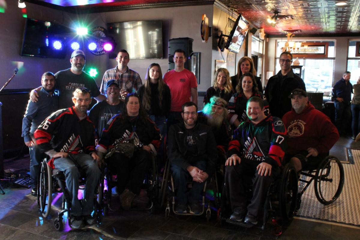 group photo of ADANC staff, board members, and Carolina Sled Hockey team