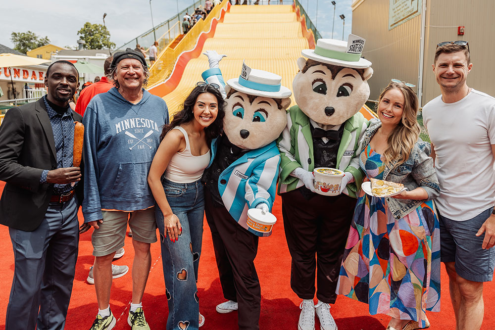 Group of Kickoff to Summer guests posing and smiling with Minnesota Staet Fair mascot, Fairborne