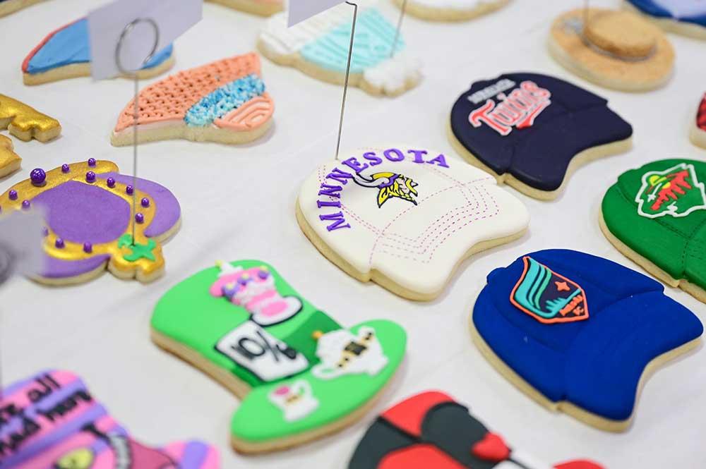 Decorated cookies shaped like hats with various Minnesota sports team logos
