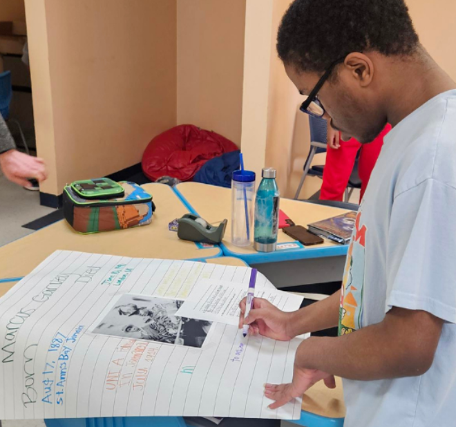 SPED student looking at smiley face occupational therapy on a blue mat