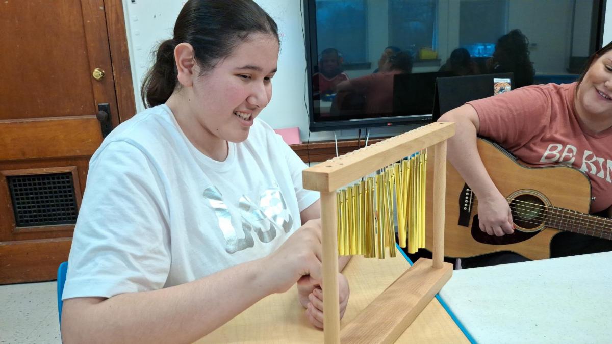 SPED student looking at smiley face occupational therapy on a blue mat