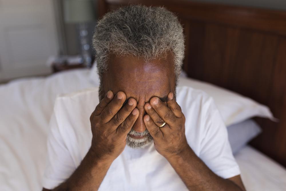 older black man wiping eyes