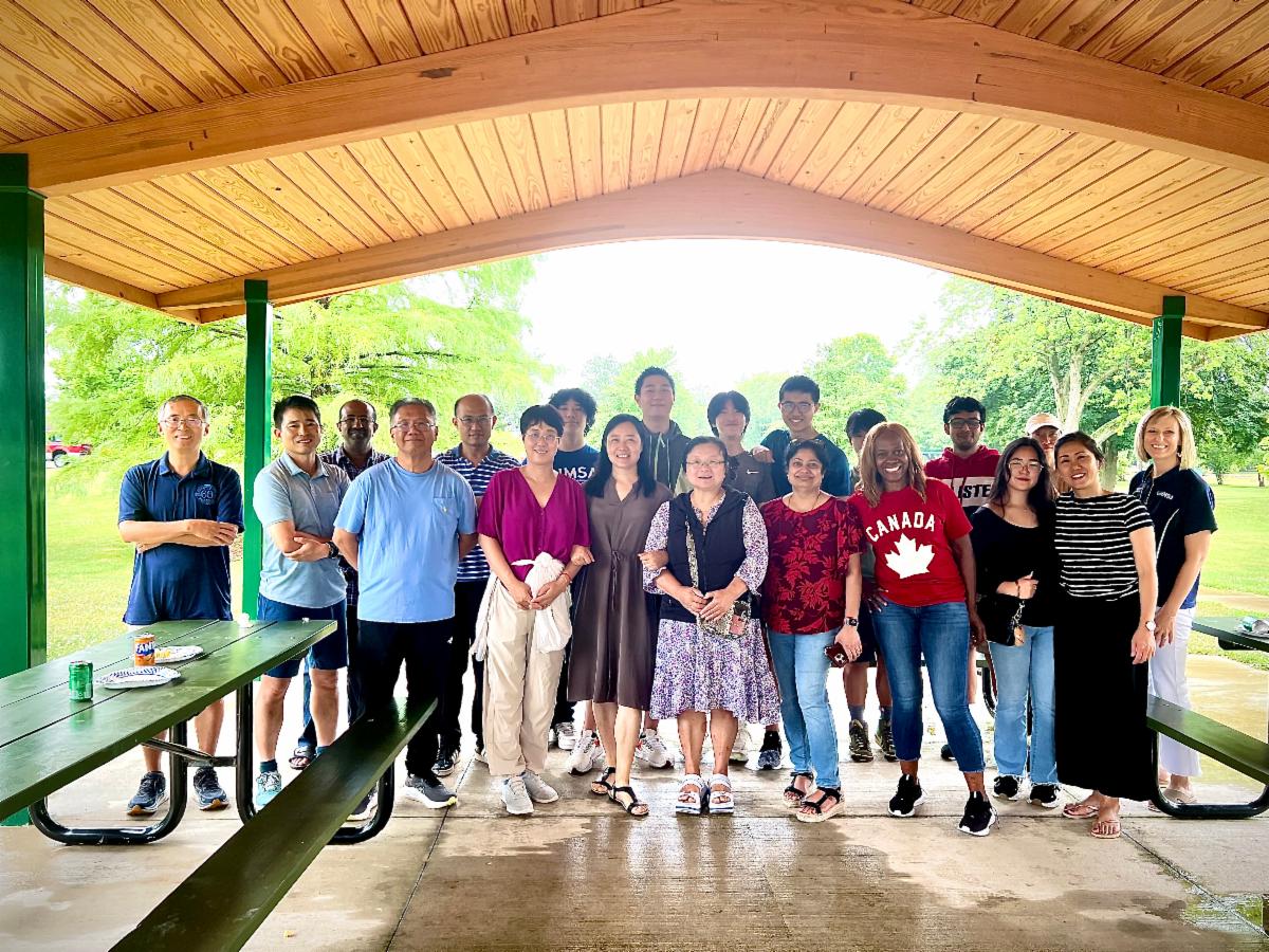 Parents and student gather under a park pavillion surrounded by picnic tables