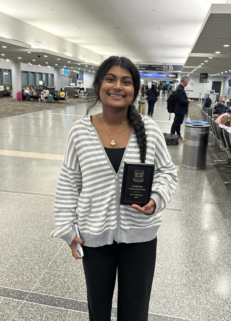 A student poses with an award plaque from the Yale Congressional Debate Tournament