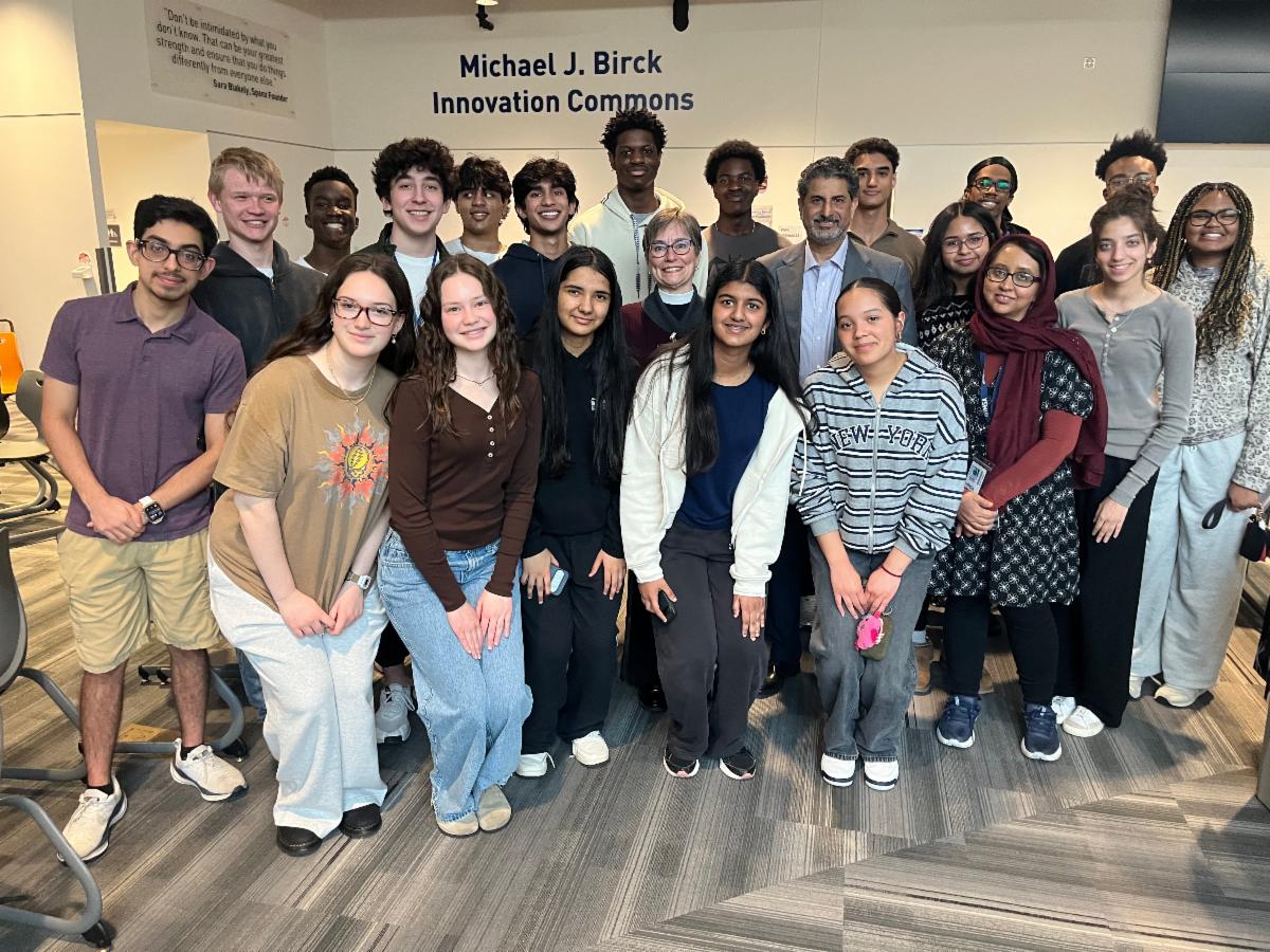 A group of students pose for a photograph in IN2 commons at the Interfaith Read In