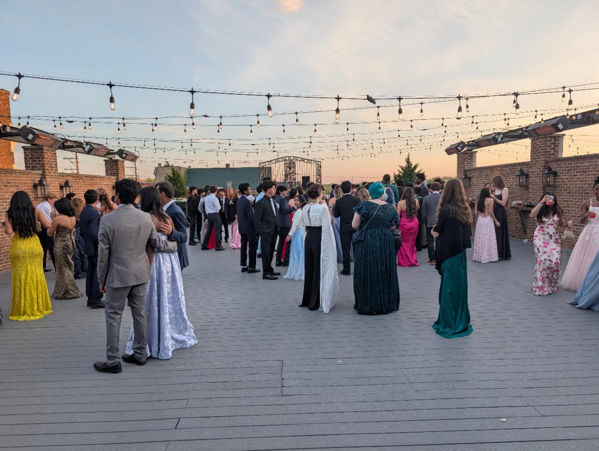 Wide shot of students on a rooftop at dusk dressed for prom