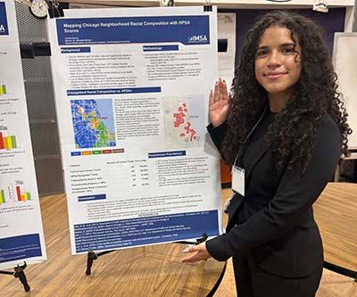 Amada Garcia stands next to her research poster on AI and medicine