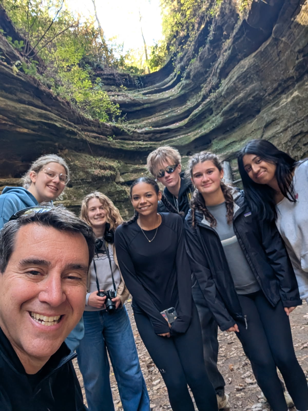 Students and chaperone pose for a selfie in front of a rock formation at Starved Rock 