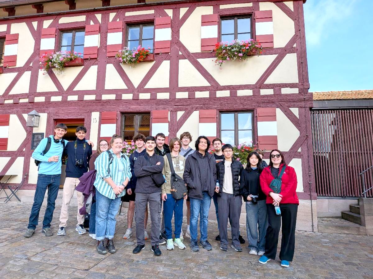 Students pose in front of a medieval town in Germany