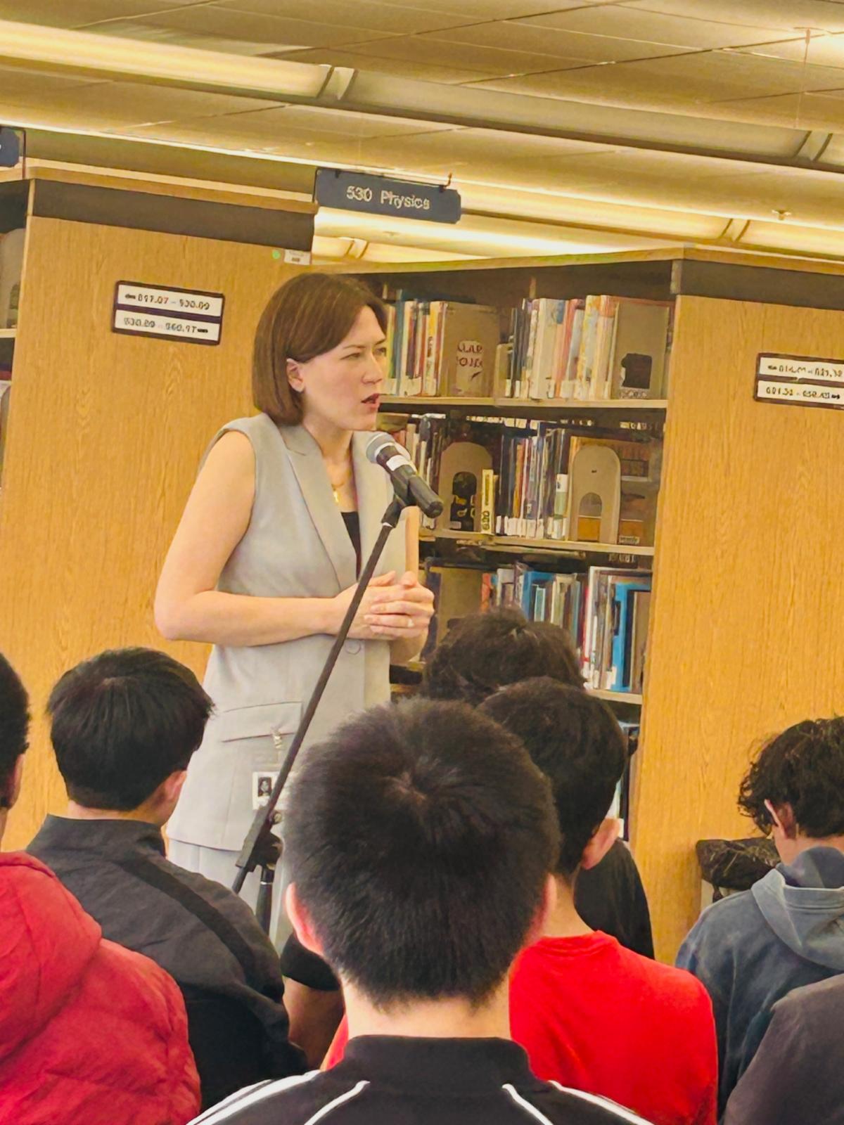 Dr. Frances Mei Hardin addresses a crowd of students in the library