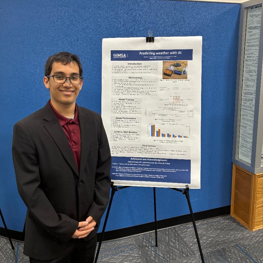 A student stands next to a poster dressed in business professional attire.