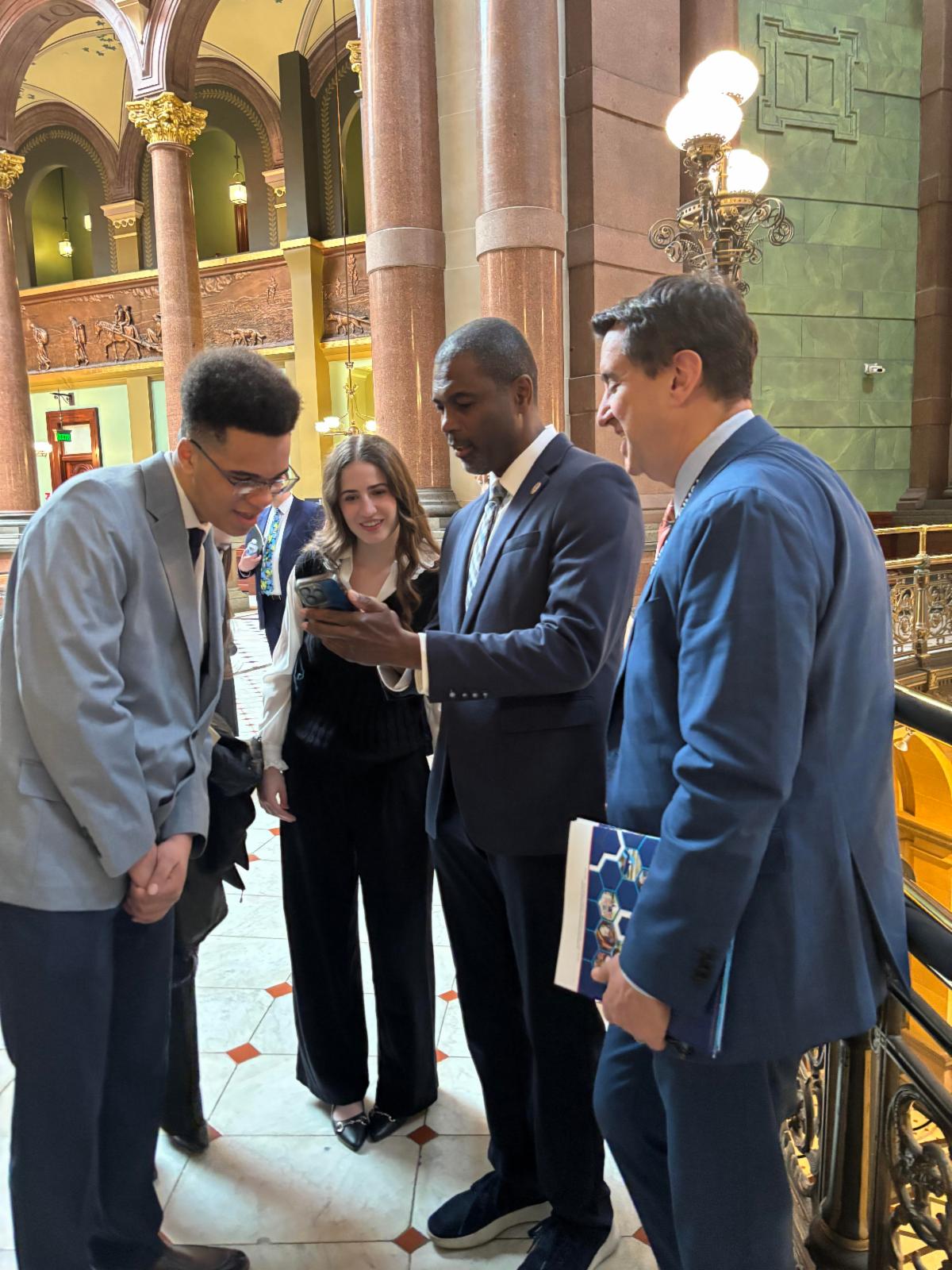 Students in business professional attire speak with Rep LaShawn K Ford
