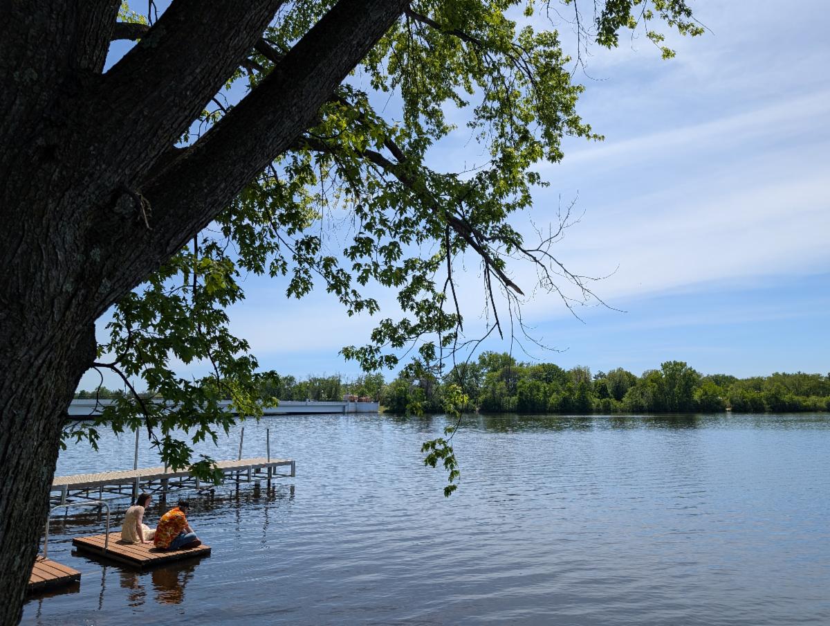 Friends sitting on dock on Wisconsin River in Stevens Point, Wisconsin
