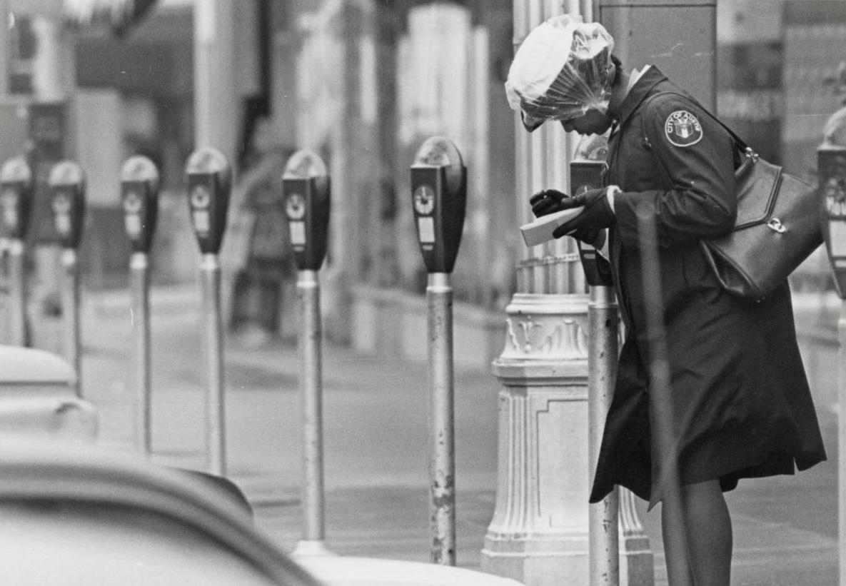 Black and White Historical Photo of Meter Maid Checking City Parking Meters