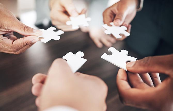 Hands hold together puzzle pieces