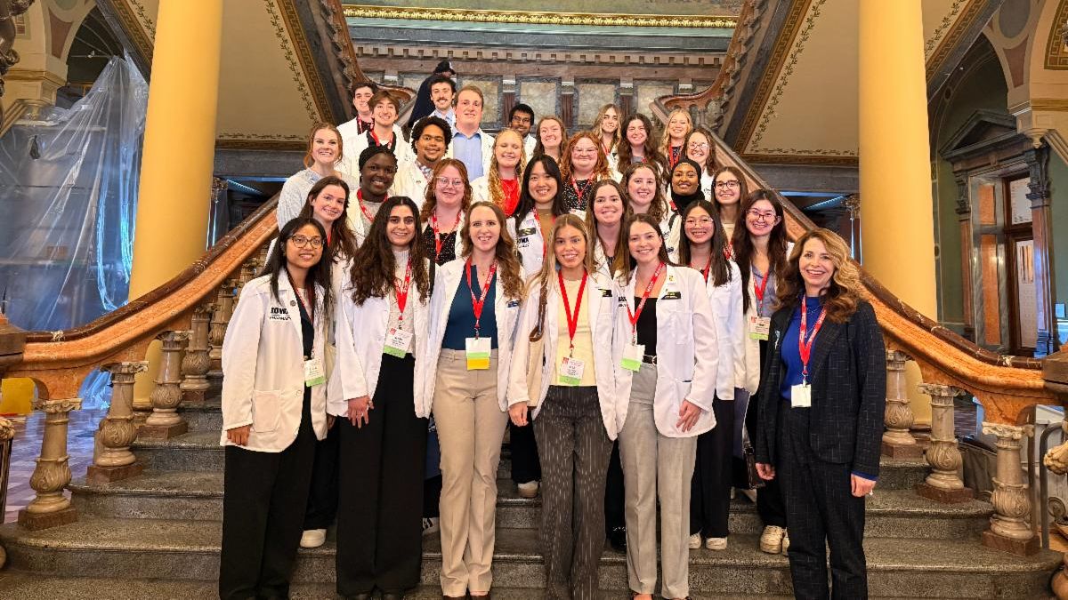 College of Pharmacy students in white coats pose on the staircase in the Iowa State capitol building during IPA Pharmacy Day on the Hill.