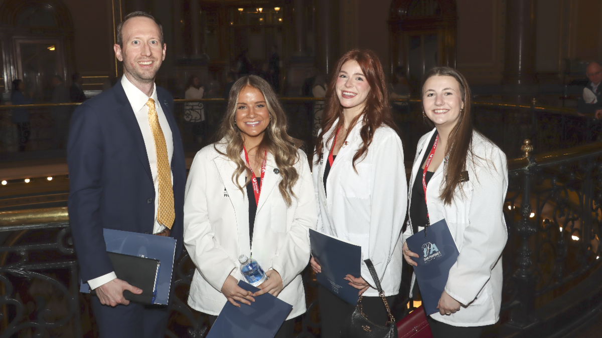 College of Pharmacy students in white coats pose in the Iowa State capitol building during IPA Pharmacy Day on the Hill.