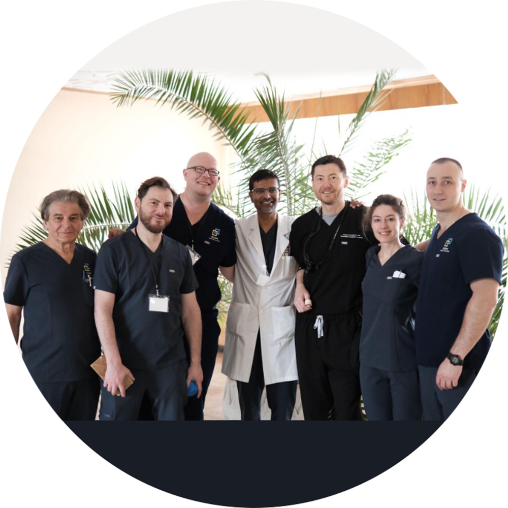 Medical professionals in scuba standing in front of a palm tree