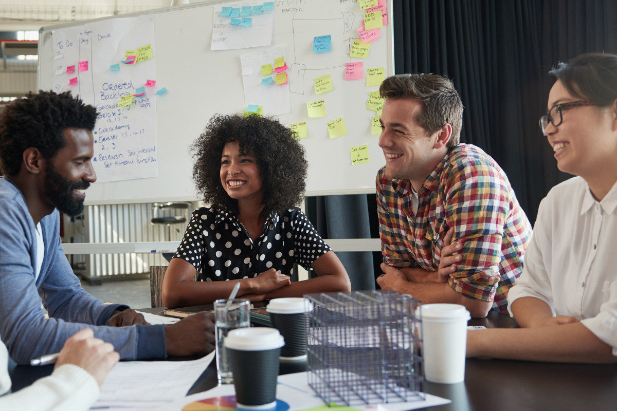 Group of young adults sitting at a table chatting.