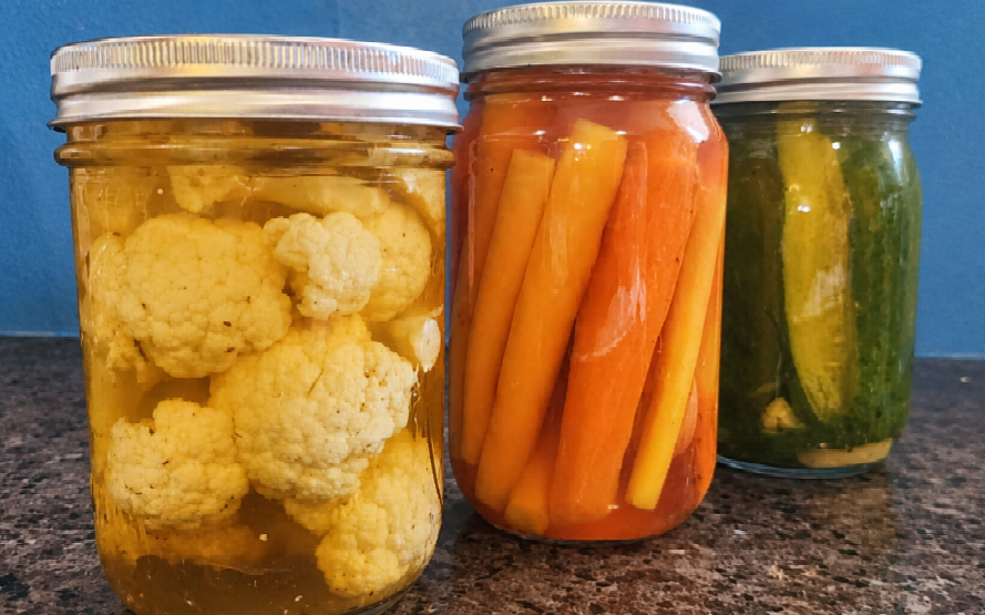 raw asparagus stuffed into a jar with flat end down