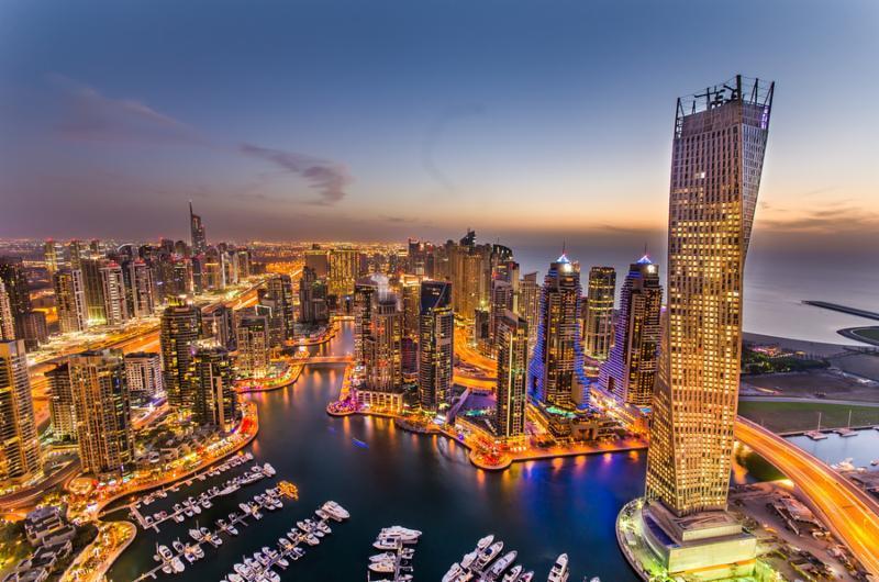 Dubai Marina at Blue hour, Glittering lights and tallest skyscrapers during a clear evening with Blue sky.