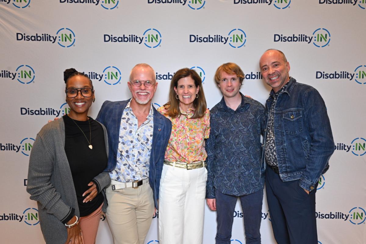 A Disability:IN step and repeat with Chciagoland partners Danata Andrews and Scott Hoesman from inQUEST Consulting standing next to Disability:IN Chicagoland Executive Director Laura Wilhelm, and Raphael Clegg-Vinell and Mark Daniels from Guidewire Software.
