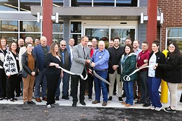 group of people cutting a ribbon