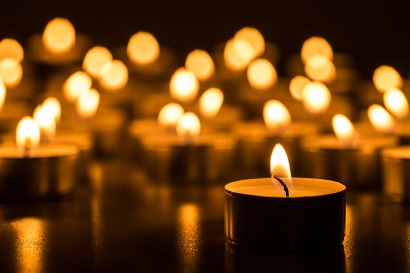 Candles light. Christmas candles burning at night. Abstract candles background. Golden light of candle flame.