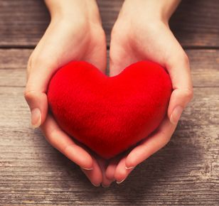 Female hands giving red heart