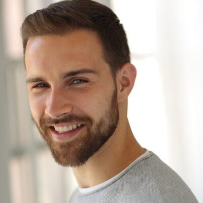 A color photo of a man smiling for a photo