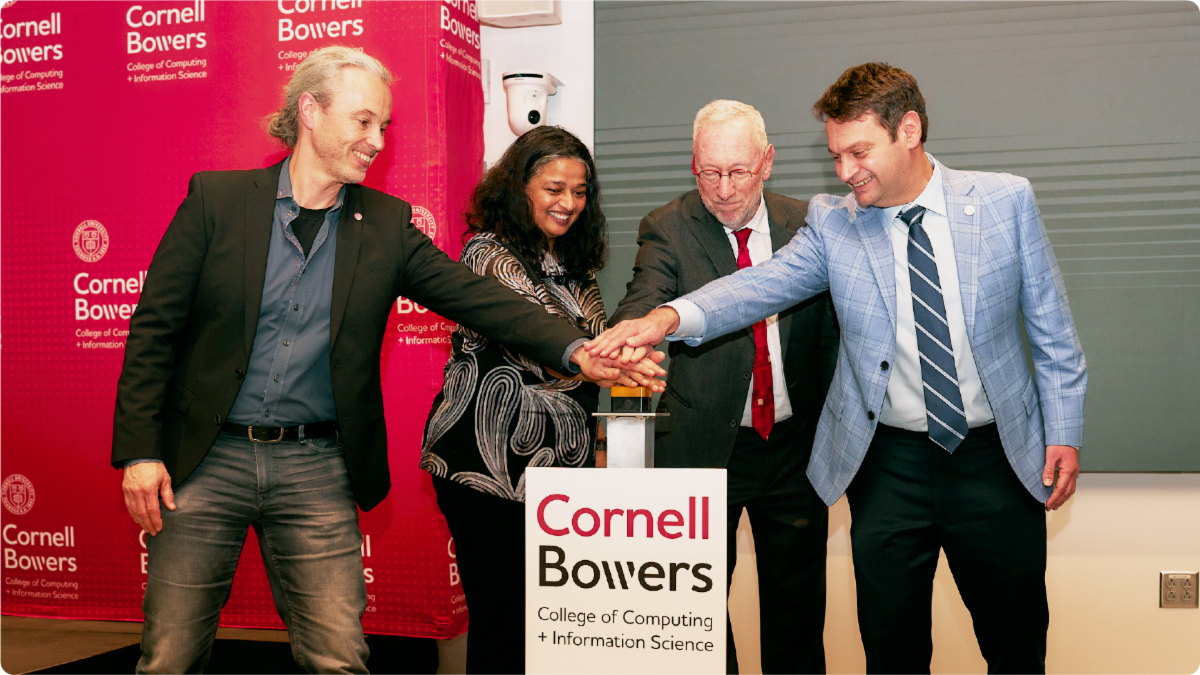 A color photo showing a group of people pushing a button at a building dedication.