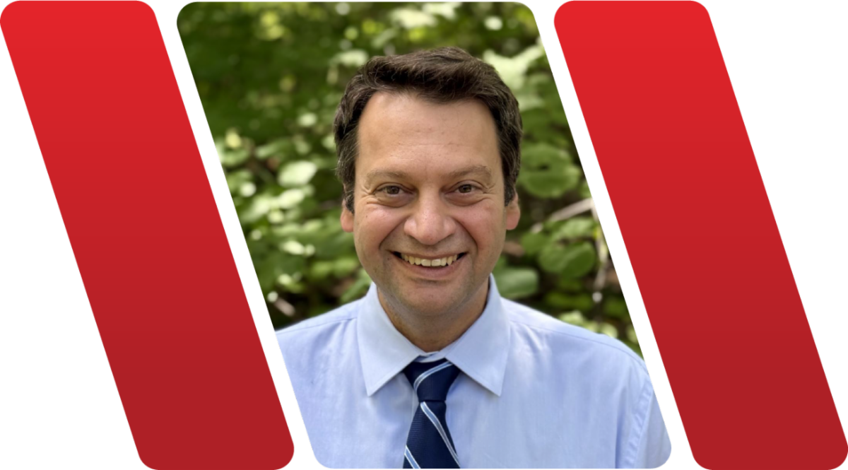 A color photo of a man smiling for a photo.