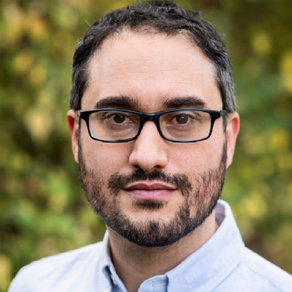 A color photo of a man with glasses.