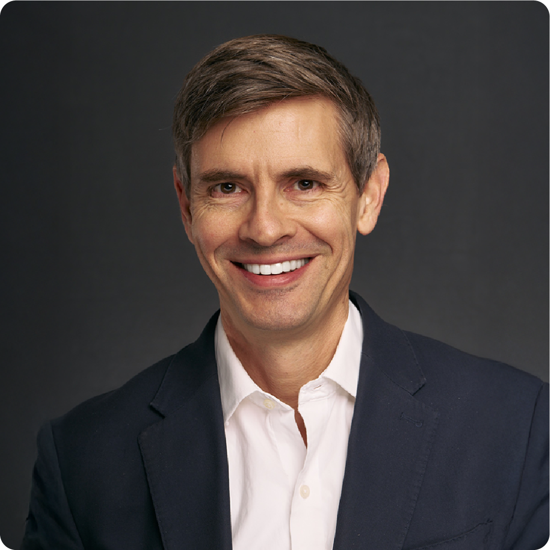 A color photo of a man smiling for a photo.