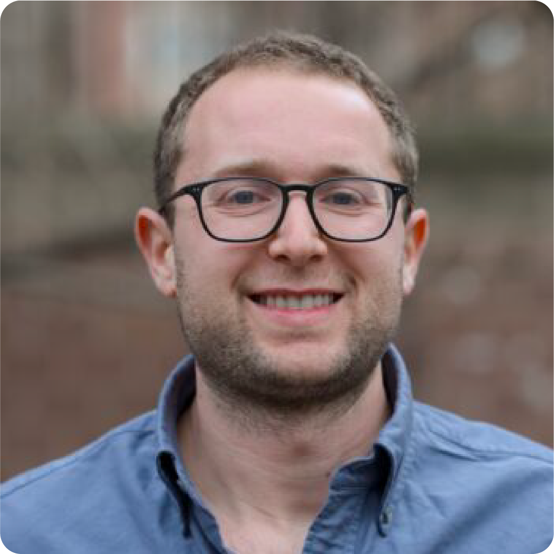 A color photo of a man smiling for a photo.