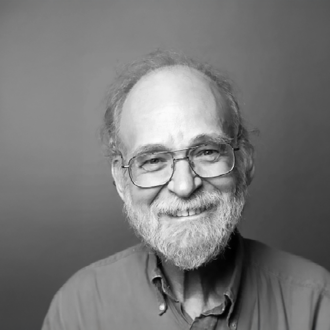 A black and white photo of a man smiling for a photo.