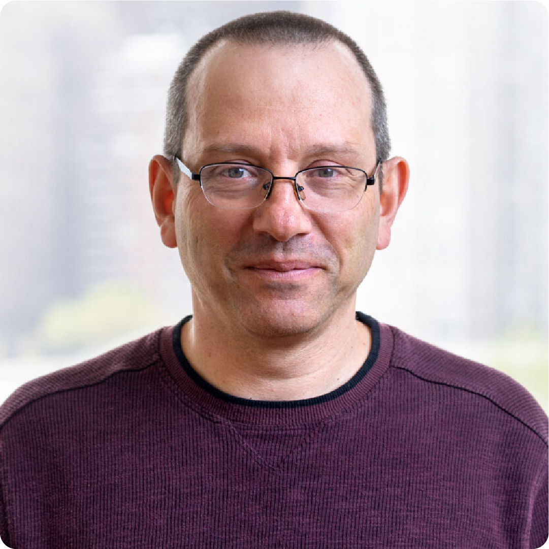 A color photo of a man smiling for a photo.