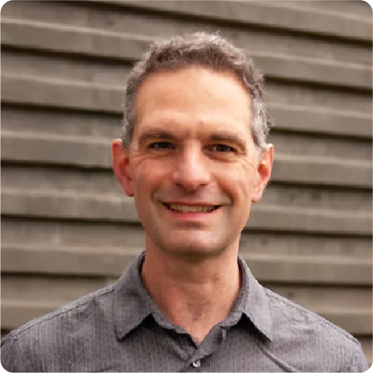 A color photo of a man smiling for a photo.