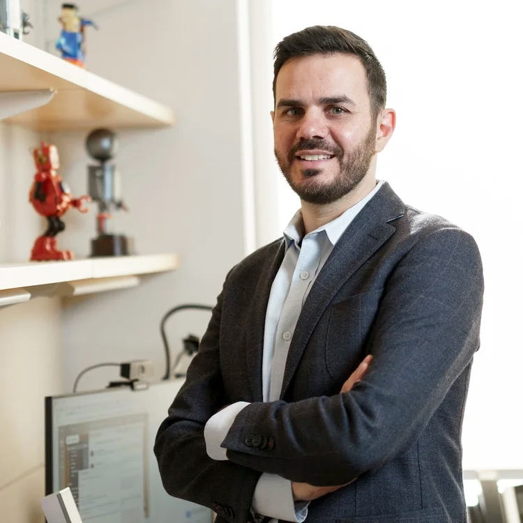A color photo of a man smiling for a photo.