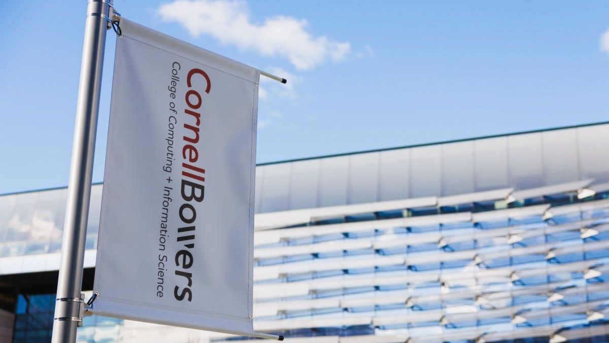 A color photo showing a vertical pole banner with the Cornell Bowers logo.