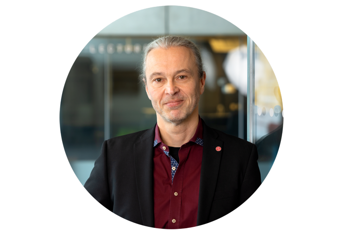 A color photo of a man smiling for a photo