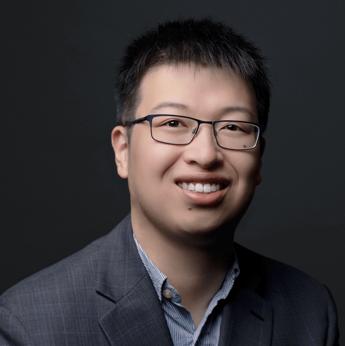 A color photo of a man smiling for a photo.