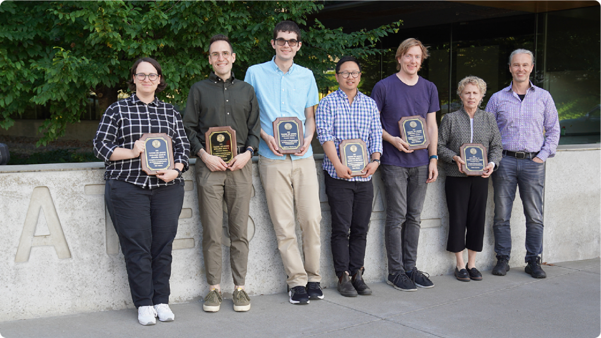 A color photo showing the faculty award winners with their plaques.