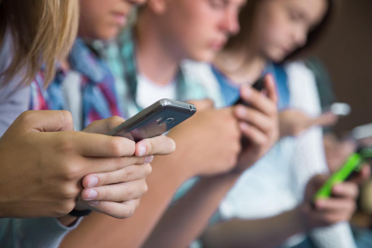 A color photo showing young people using their cell phones