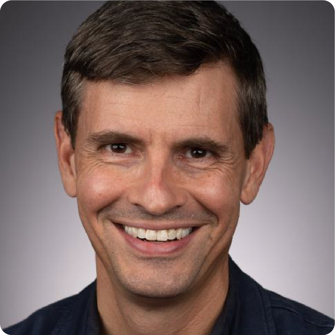 A color photo of a man smiling for a photo